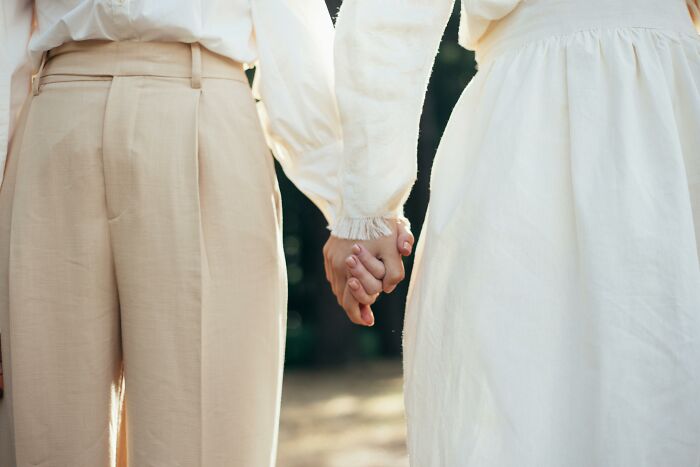 Two people holding hands, symbolizing the sharing of secrets.