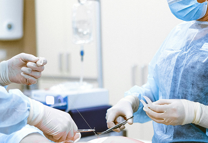 Medical team in surgical attire performing a procedure.