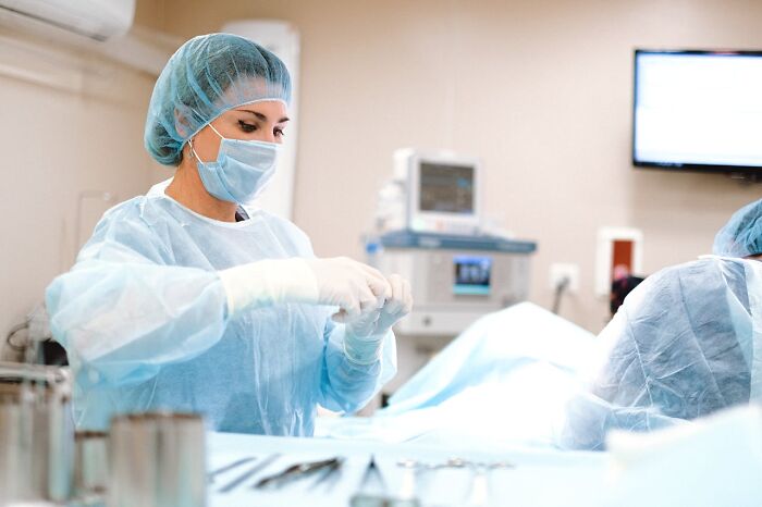 Doctor in surgical attire, preparing for procedure, highlighting exercise as key advice from experience.