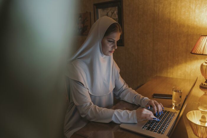 Person working on a laptop in a peaceful, quiet room with soft lighting.