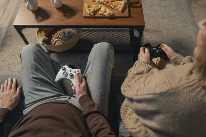 Two people playing video games with pizza on the table, a typical scene following an unexpected "You Up?" text.