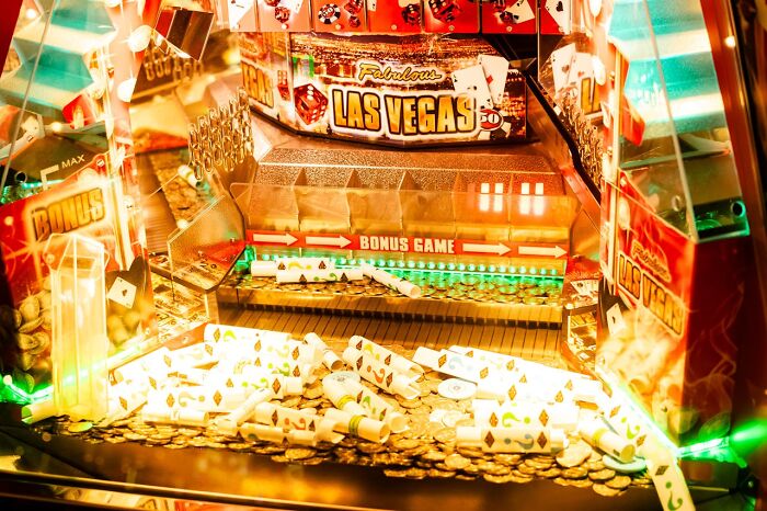 Las Vegas casino machine with colorful lights, bonus game, and scattered coins.