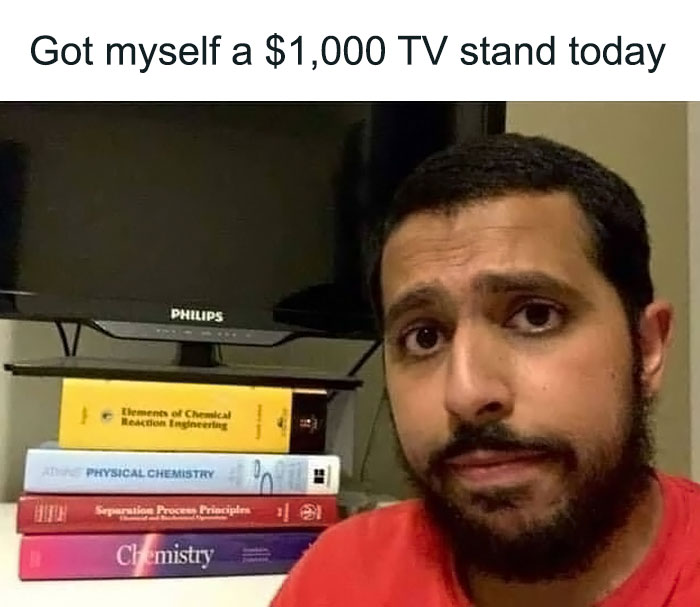 Man humorously uses science textbooks as a TV stand, showcasing relatable science meme humor.