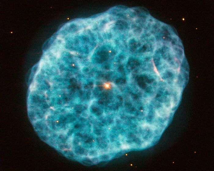 Beautiful blue nebula glowing in space with stars twinkling in the background.