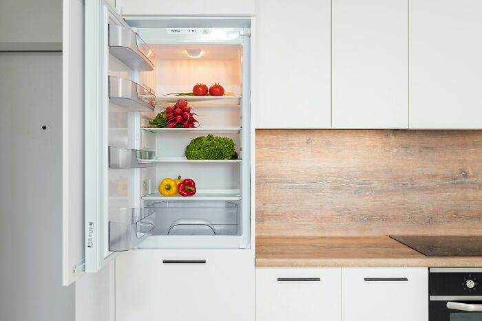 Open fridge with fresh vegetables inside, a popular gift choice for retirees.