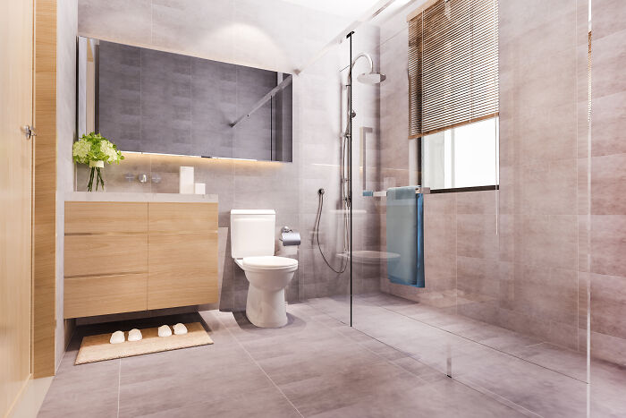 Modern bathroom design with glass shower, wooden vanity, and large mirror, reflecting retirees' gift to themselves for relaxation.