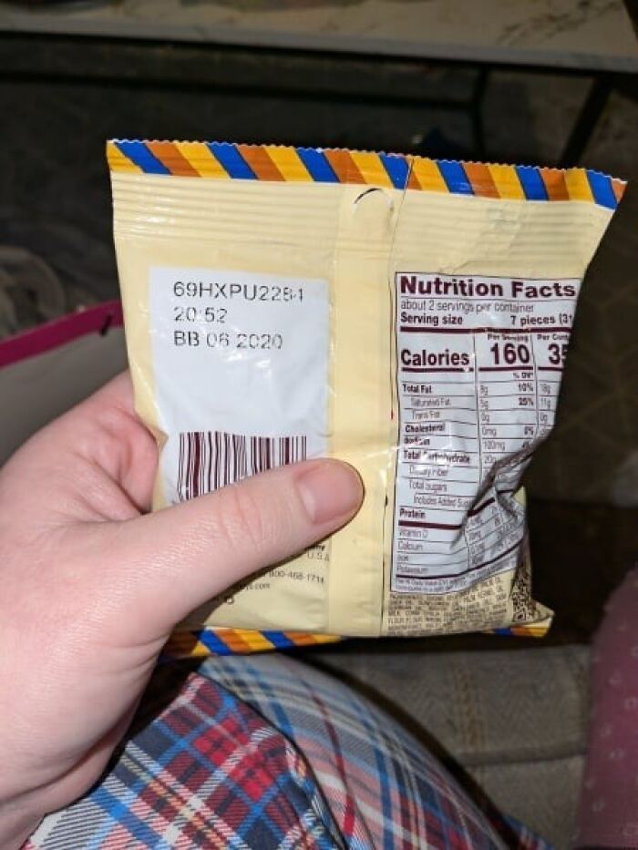 Expired snack being held, showing a best before date from 2020 on the packaging, related to Secret Santa gift.