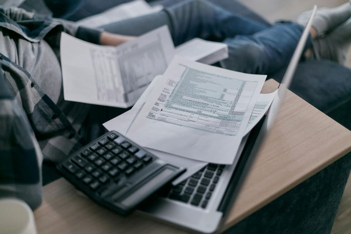 Calculator and papers on a desk, symbolizing clearing debt for many people.