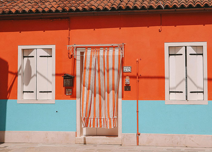 Colorful house with striped curtain, showcasing homeowner creativity against HOA rules.