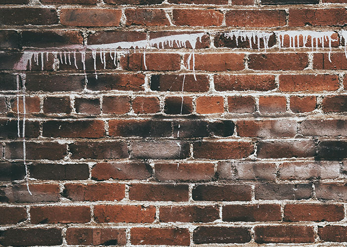 Brick wall with streaks of paint, symbolizing homeowners opposing their HOA.