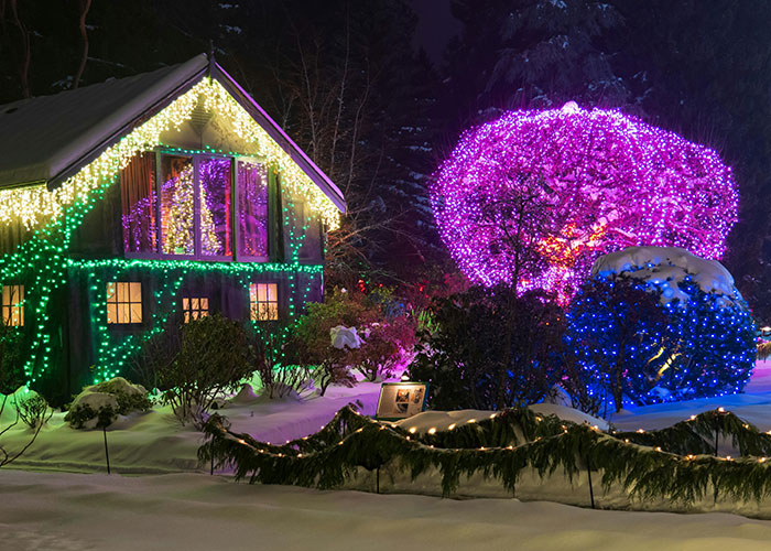 Festive home with colorful lights in winter, showcasing homeowner creativity against HOA.