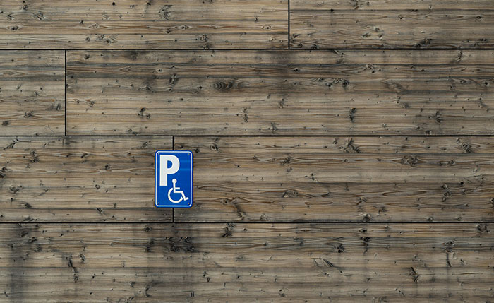 Blue handicapped parking sign on a wooden wall captures the essence of Canadian.