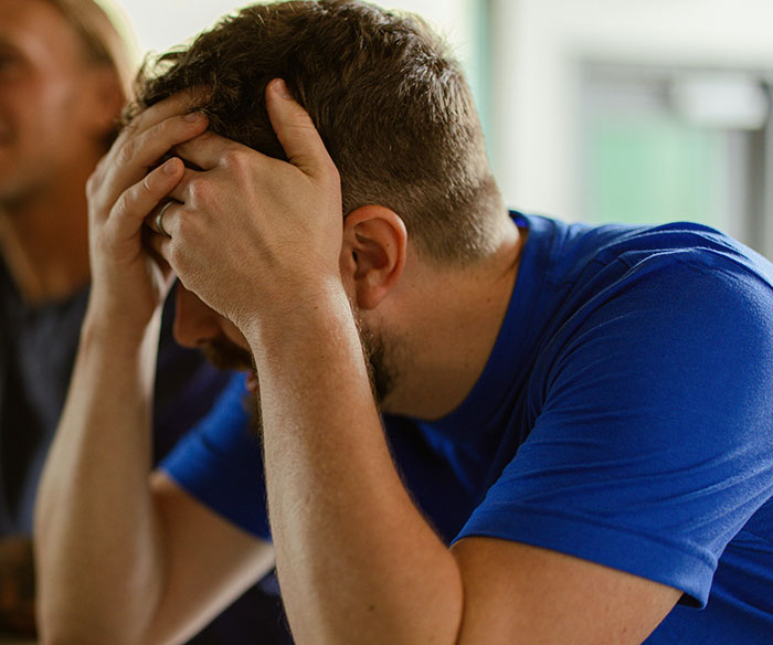 Man in a blue shirt, looking frustrated after being asked a confusing question about Canadian language.