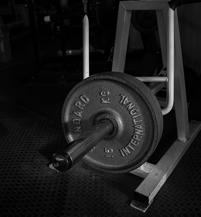 A weight plate on a gym machine barbell, emphasizing fitness equipment.