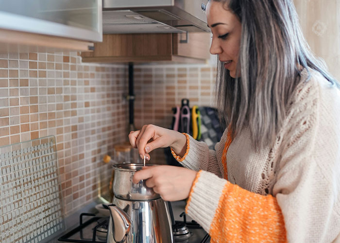 Person cooking in the kitchen, illustrating a situation where police were called for a trivial reason.