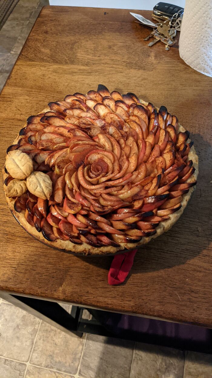 Beautifully arranged apple pie on a wooden table, showcasing intricate layers that foodies will absolutely love.