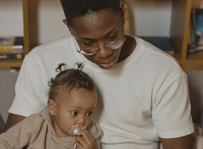 Father and baby sitting together, capturing a moment of bonding within a large family.