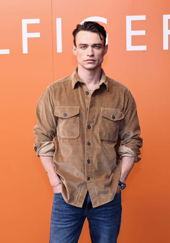 Man from Tell Me Lies cast in a brown shirt against an orange background.