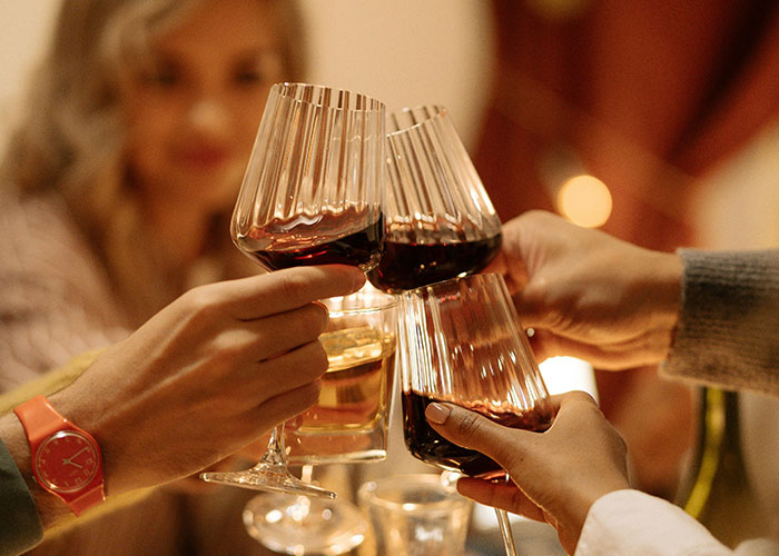 Thanksgiving toast with wine glasses, close-up of hands celebrating.