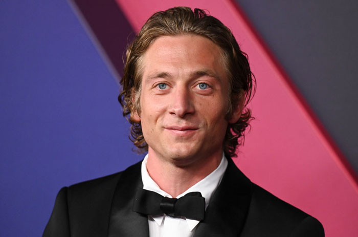 Jeremy Allen White smiling in a formal tuxedo at an event, representing "The Bear" cast with stars and guest appearances in Season 3.