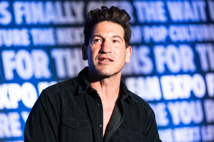 Jon Bernthal speaking at an event, with a text-filled background, possibly related to The Bear cast in Season 3 appearances.