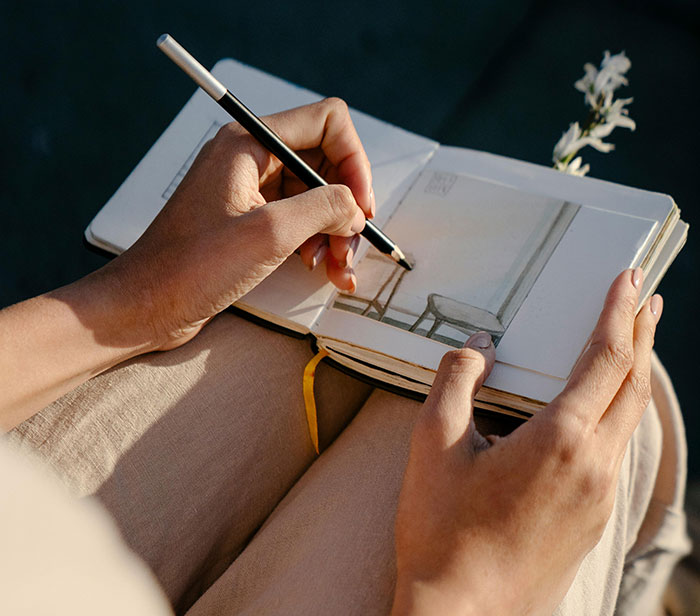 Person sketching in a journal, highlighting their unique rare statistics with creative expression.