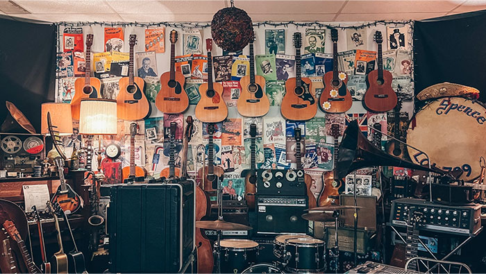 Room filled with vintage musical instruments and memorabilia, featuring items adults bought after being denied in childhood.