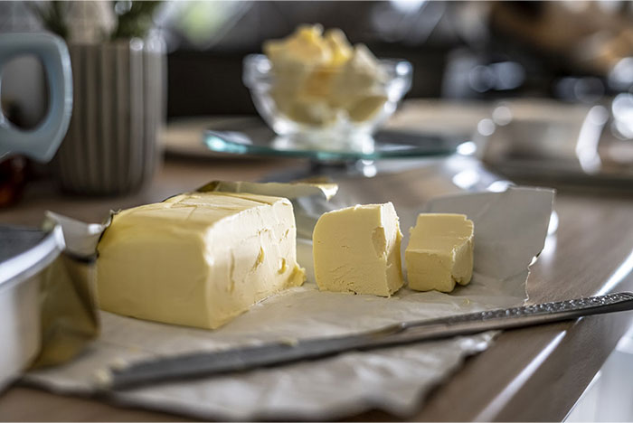 Butter on a table, reflecting items purchased by adults who lacked them in childhood.