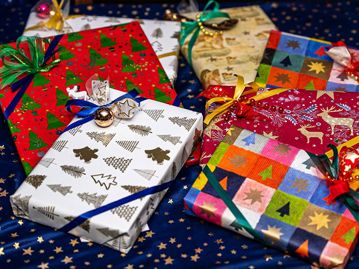 Colorful, wrapped gifts with festive patterns on a starry backdrop, representing things bought as adults denied in childhood.