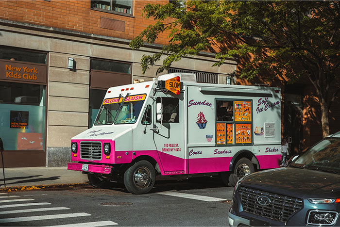 Ice cream truck parked on a city street, representing things bought by adults denied childhood treats.