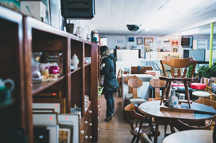 A person browses through a vintage store filled with furniture and decor, exploring items they were denied in childhood.