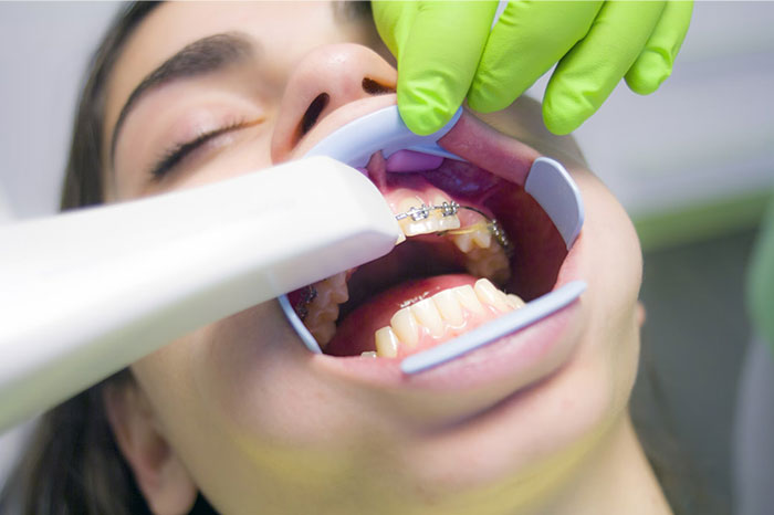 Adult receiving dental care, wearing braces, representing things people bought as adults denied in childhood.