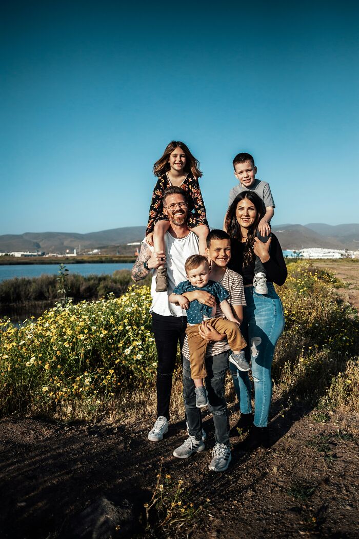 Family smiling together outdoors, demonstrating things people judge others for, like appearance and fashion choices.