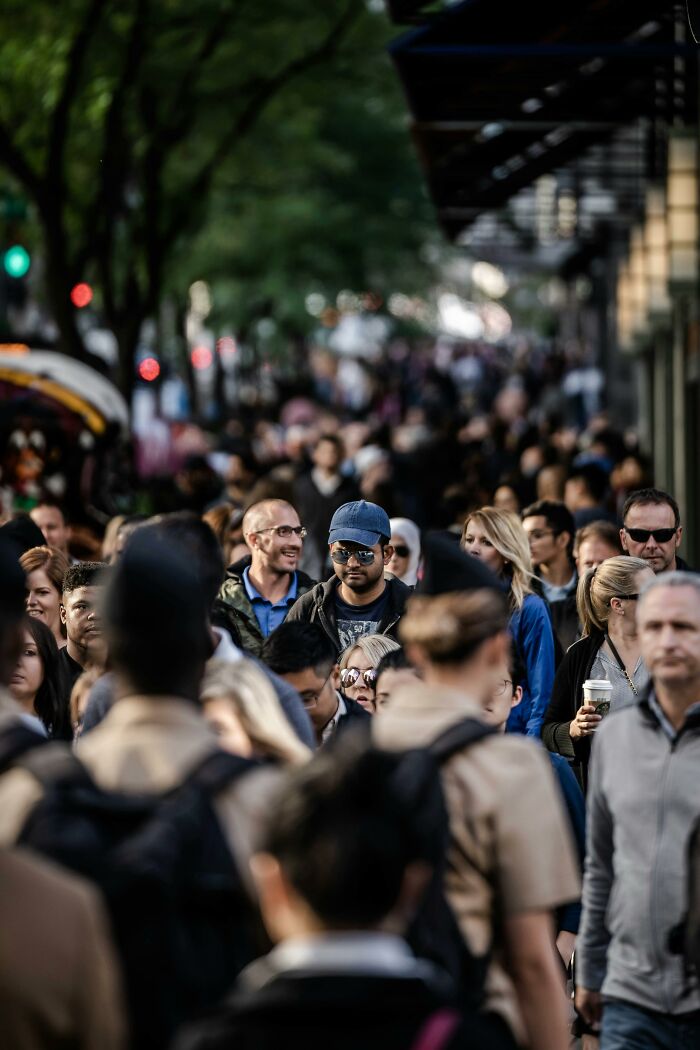 A busy street crowded with diverse people walking, highlighting things people secretly judge others for.