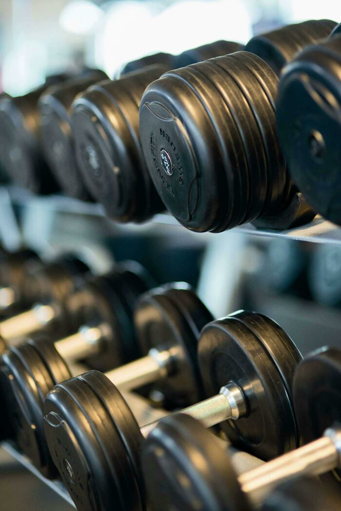 Rows of black dumbbells in a gym, a common subject of secret judgment among fitness enthusiasts.