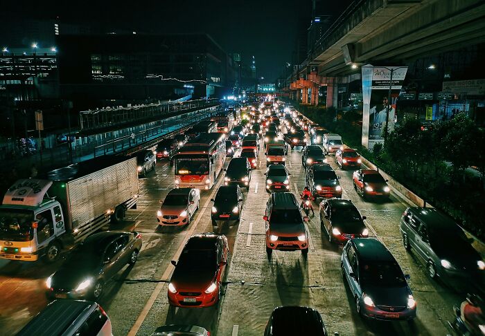 Heavy traffic at night, with cars lined up on a busy street, illustrating things people judge others for.