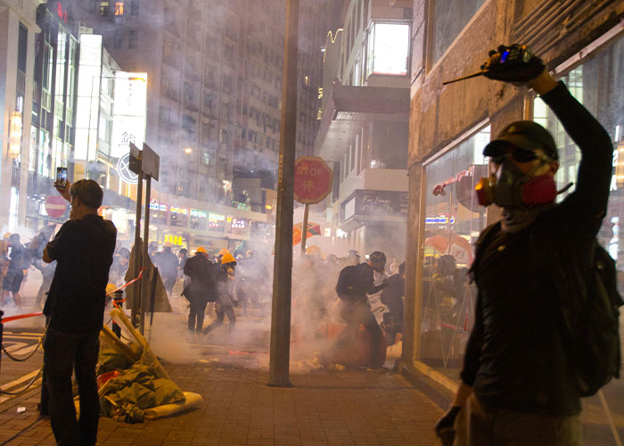 Urban protest with people in masks amid smoke, highlighting the terrible aspects of sought-after events.