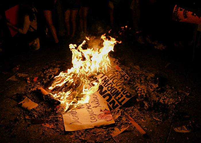 Burning protest signs at night illustrating things people want are actually terrible.