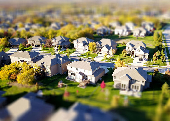 Suburban neighborhood with houses and green lawns, illustrating things-people-want-actually-terrible aspects of urban living.