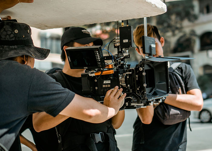 Film crew operating a camera outdoors, capturing a scene, highlighting things people want that are actually terrible.