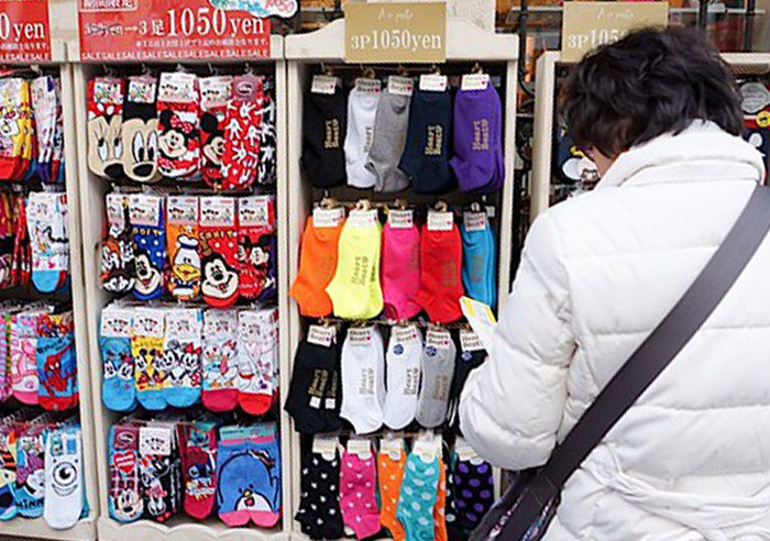 Person in white coat shopping for colorful socks, illustrating family dynamics.