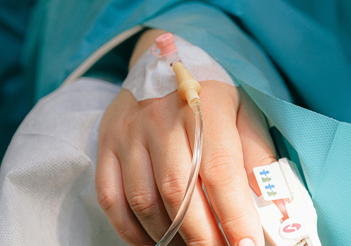 Close-up of a hand with an IV, highlighting toxic family dynamics and emotional distress.