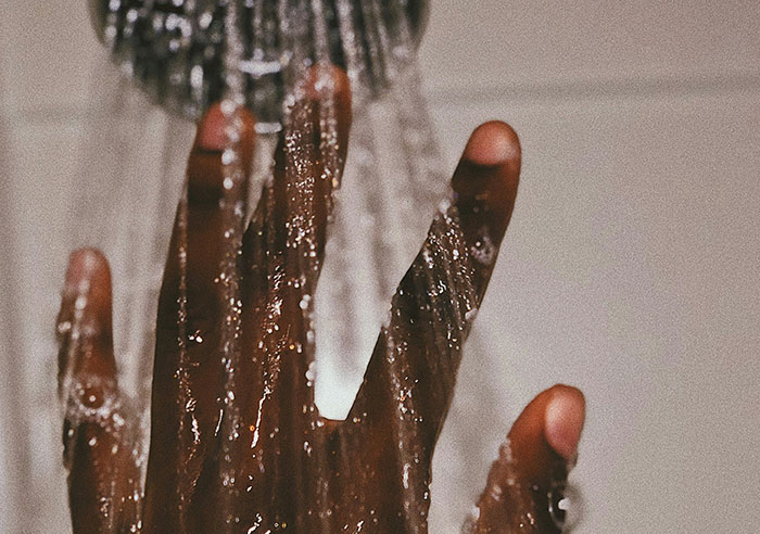 Hand under running water, symbolizing toxic family dynamics.