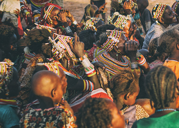 A group of people in colorful traditional attire attending an event outdoors.