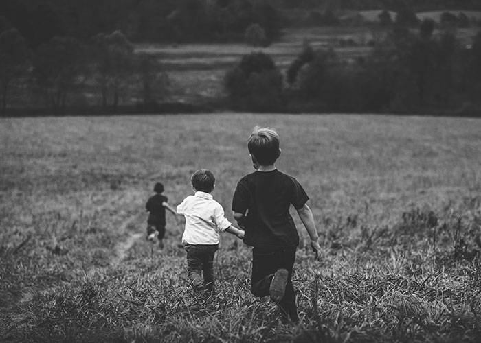 Children running in a field, evoking mystery and adventure.