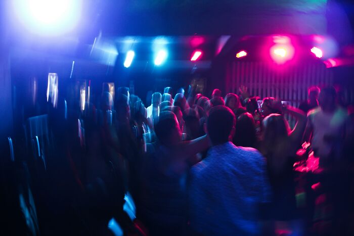 Blurry dance floor with colorful lights, vibrant party scene.