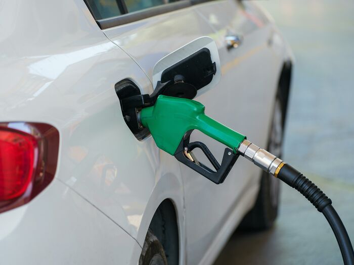 A car being filled at a gas station, illustrating the concept of wastefully exorbitant spending.