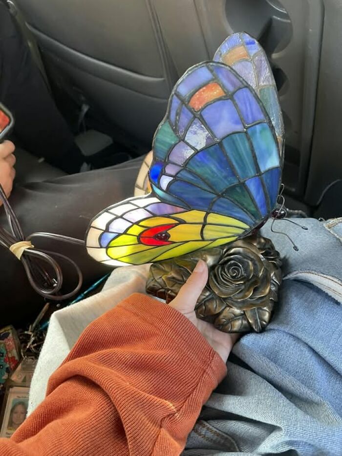 Stained glass butterfly lamp with colorful wings, a unique second-hand discovery held in hand.