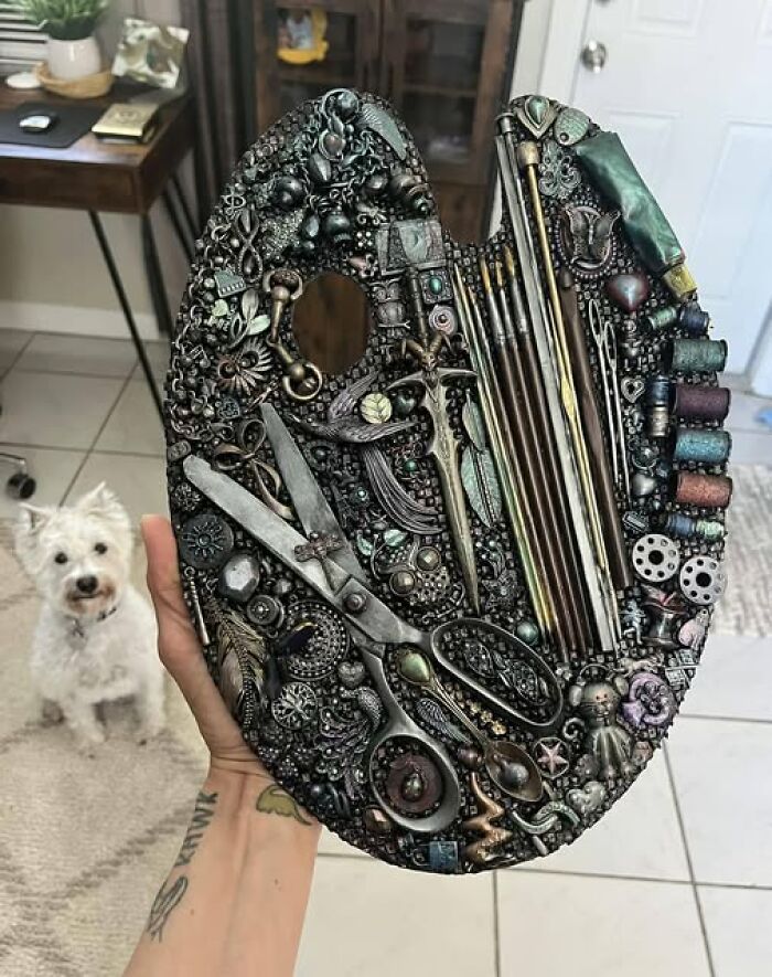 Second-hand discovery: a decorative art palette made of various repurposed metal objects and tools, held by a tattooed hand.