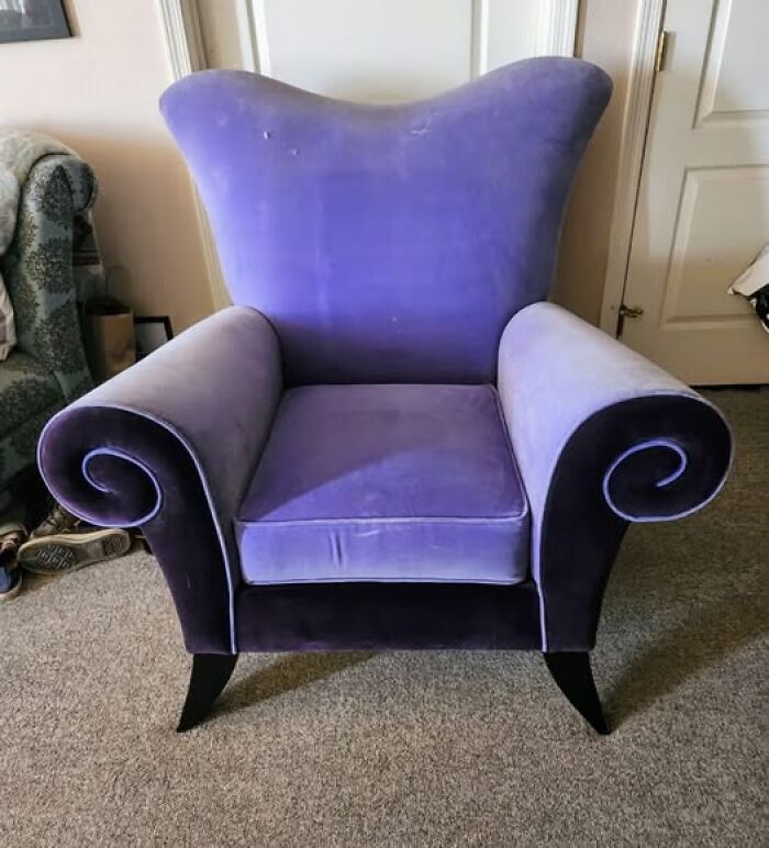 Purple high-back chair with curled armrests, showcasing strange and spectacular second-hand design.